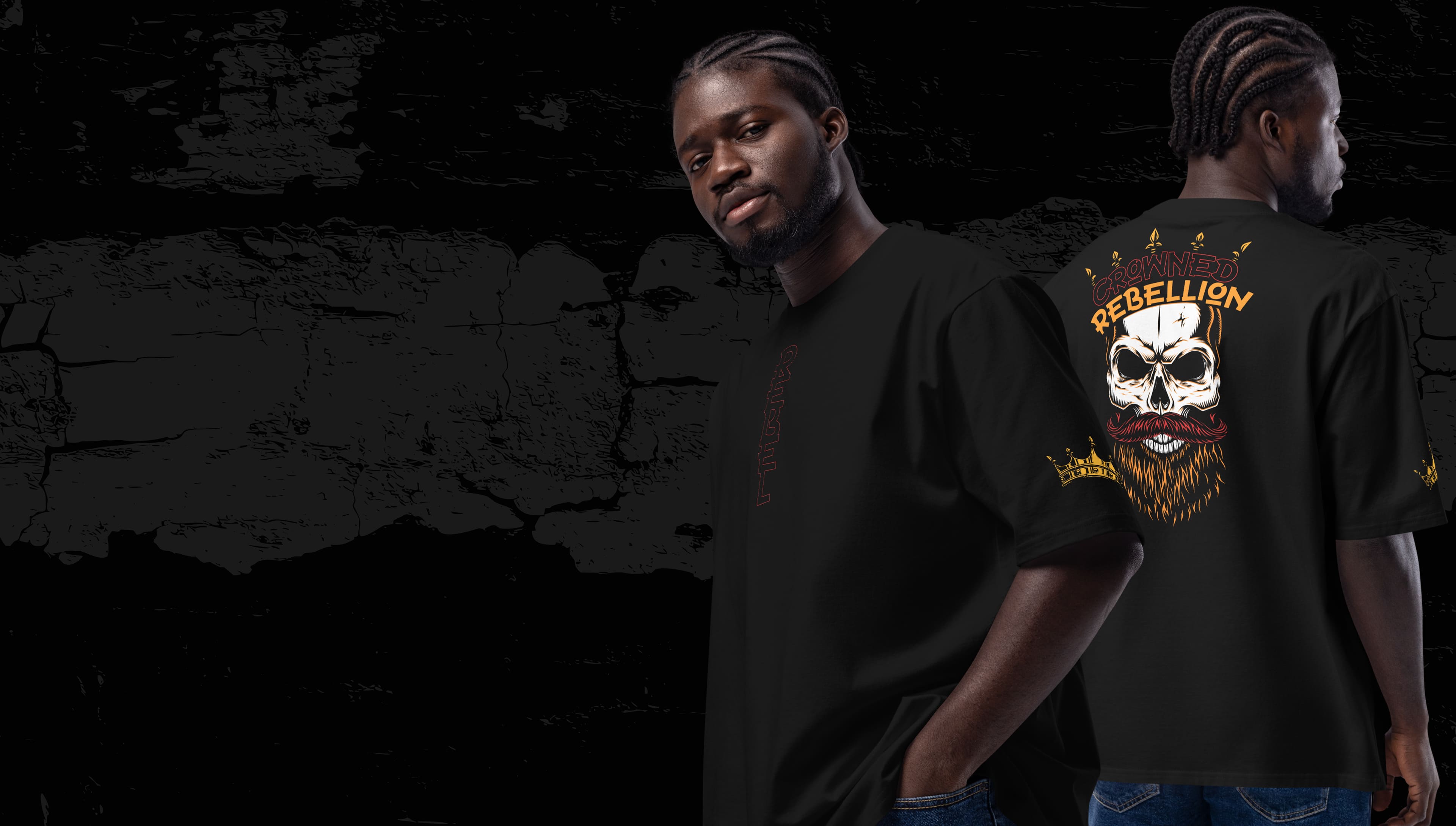 A man modeling a black oversized T-shirt with a bold design. The back of the shirt features a graphic of a skull with a beard, surrounded by flames and crowned with text reading "Crowned Rebellion." The front shows a minimalist logo in the chest area. The model stands confidently against a dark, textured background, exuding a rebellious and edgy vibe.