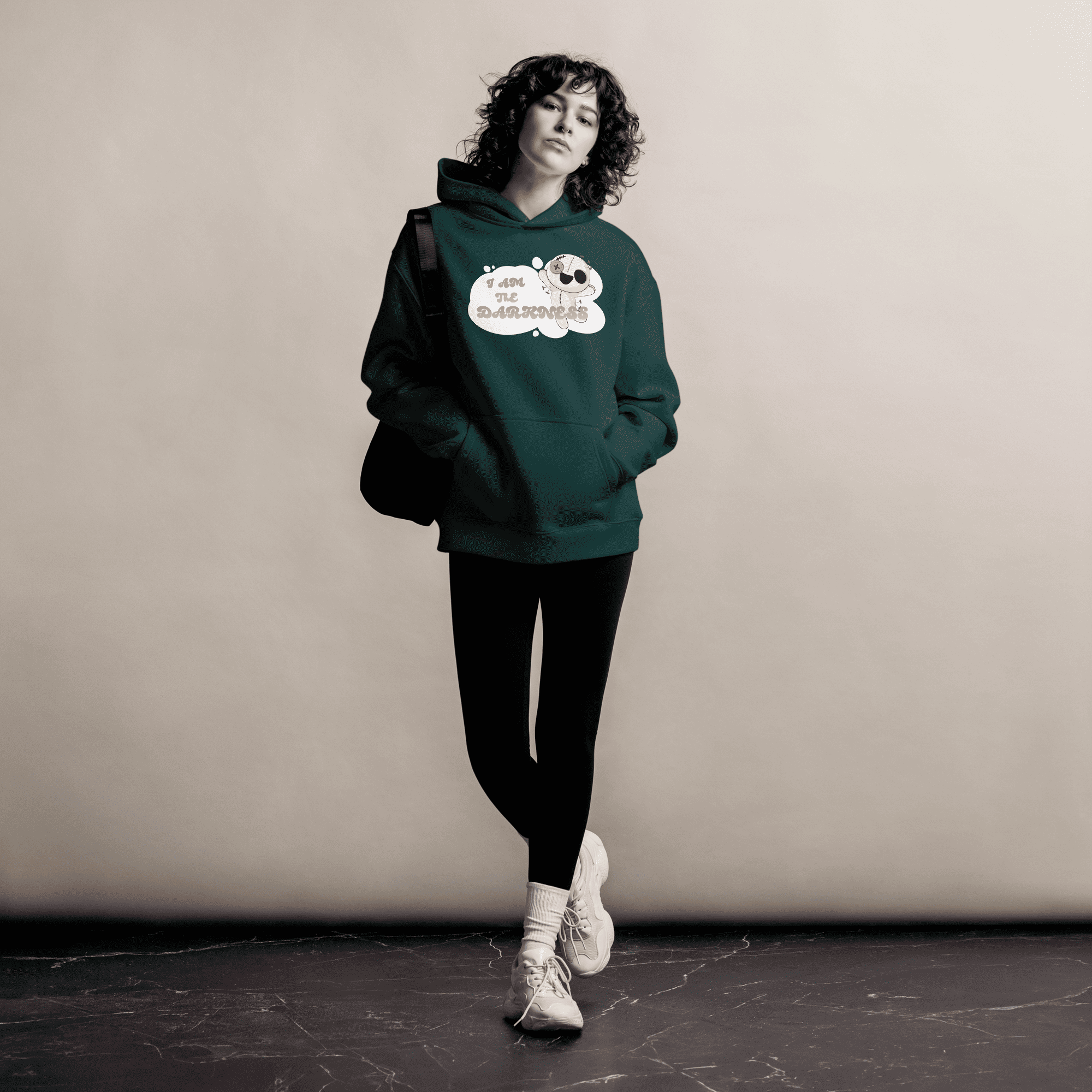 A woman in a green hoodie featuring a funny design, smiling and enjoying her casual look.